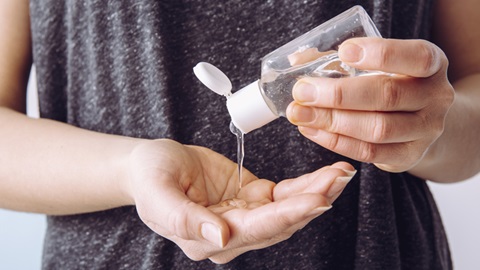 Mulher a usar álcool gel nas mãos